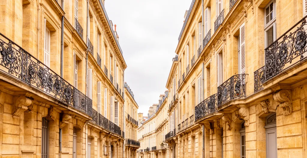Rue typique de Bordeaux avec façades en pierre blonde et balcons français